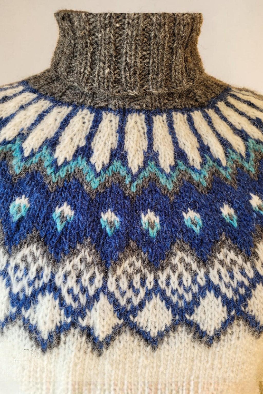 Detail Rundpasse Islandpullover Alfheidur Nordic Sea handgestrickt mit nordischem Muster in Blau, Petrol und Naturweiß