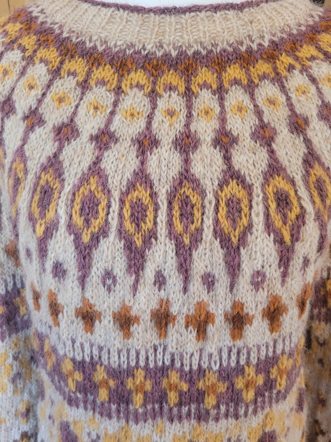 Detailaufnahme der traditionellen Rundpasse des Katmandu Islandpullovers. Das klassische Lopapeysa Muster zeigt die handgestrickte Struktur der isländischen Lettlopi Wolle besonders deutlich.