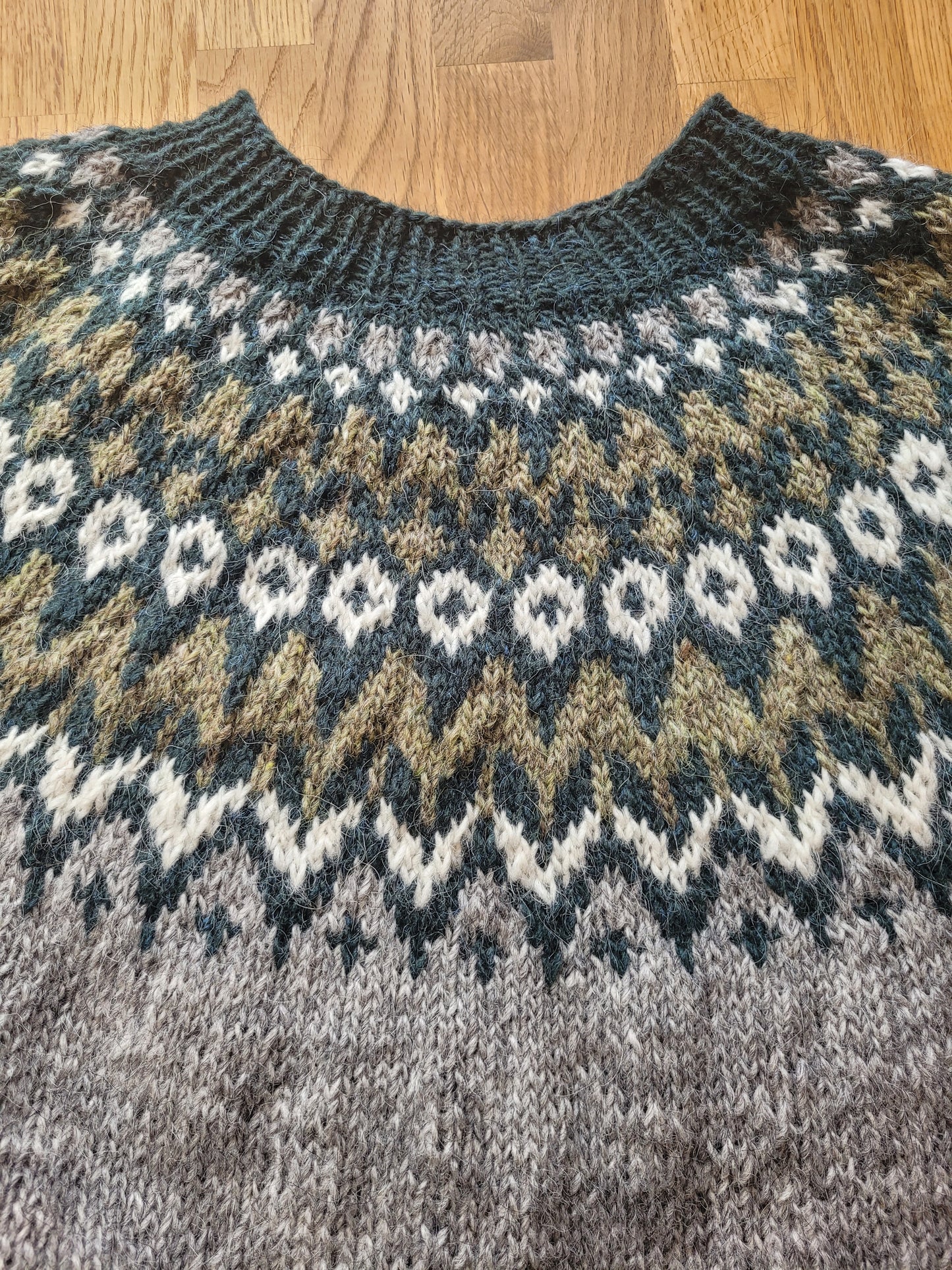 Ärmeldetail eines handgestrickten Islandpullovers Riddari aus Lettlopi mit nordischem Muster und Rippenbündchen