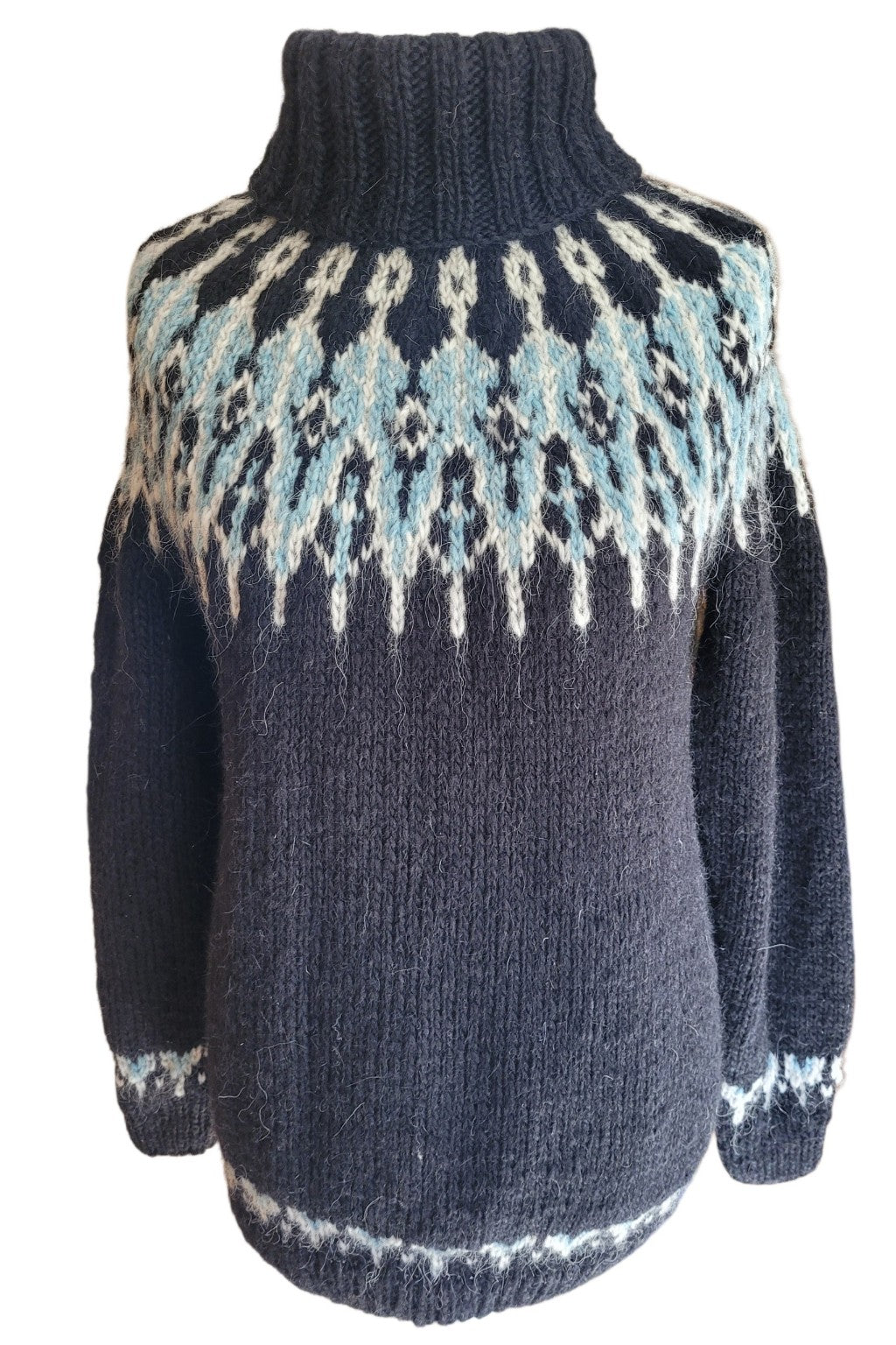 Handgestrickter Islandpullover Tusseladd aus isländischer Álafosslopi-Wolle in Schwarz mit eisblauer und naturweißer Rundpasse, fotografiert auf einer Schneiderpuppe vor weißem Hintergrund.