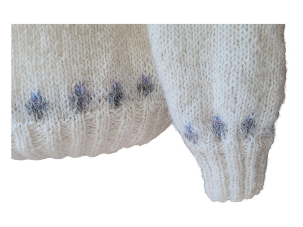 Detailaufnahme des Ärmels von Ískaldur in Winter Light mit dem handgestrickten Muster aus Hellgrau, Silbergrau und Milky Way auf heller Léttlopi-Wolle.