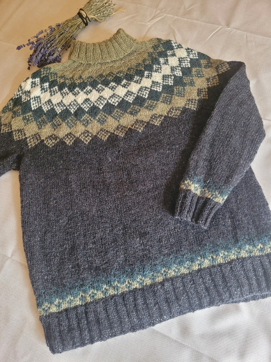 Handgestrickter Islandpullover aus isländischer Lettlopi-Wolle in Anthrazit, Moosgrün und Naturweiß mit traditioneller isländischer Rundpasse.