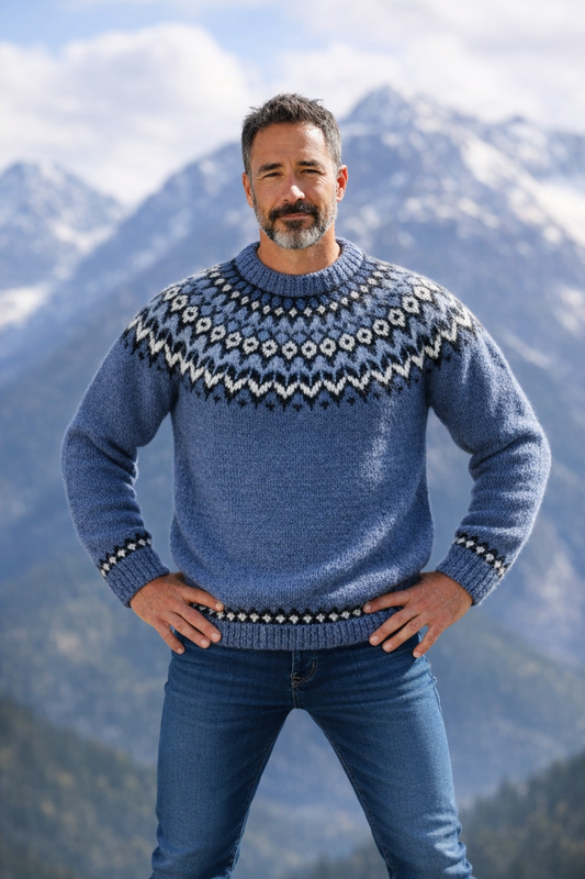Handgestrickter Islandpullover für Herren in Blau mit nordischer Rundpasse aus reiner Wolle vor Bergkulisse