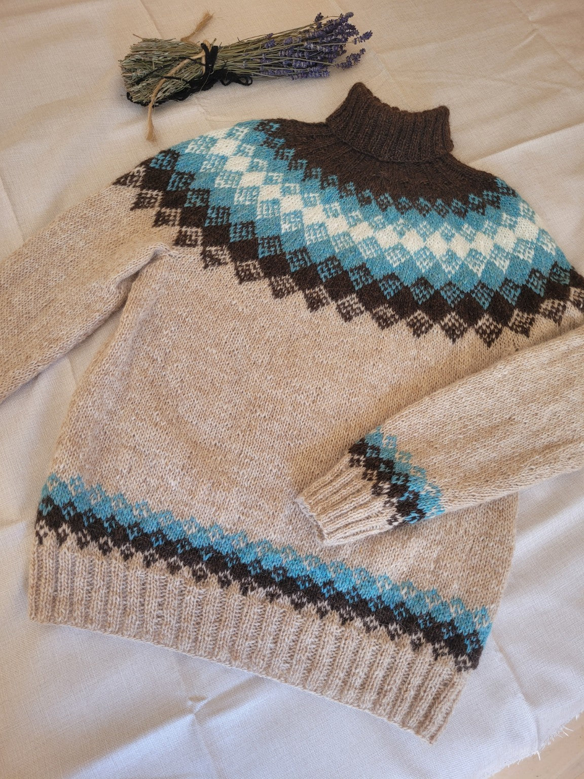 Handgestrickter Islandpullover aus isländischer Lettlopi-Wolle in Natur, Türkis, Braun und Weiß mit traditioneller Rundpasse.