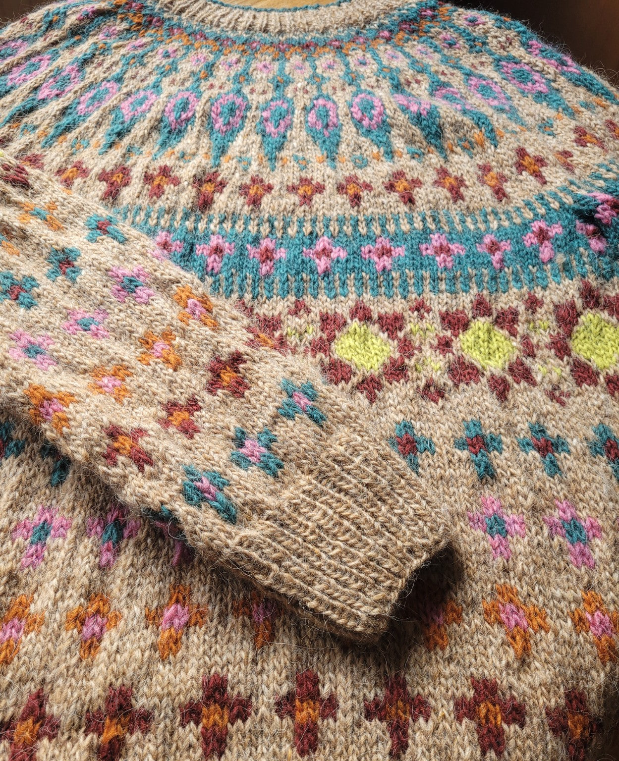Detailaufnahme des mehrfarbigen Katmandu Musters aus Lettlopi Wolle, sorgfältig handgestrickt in traditioneller Fair-Isle-Technik. Armbündchen