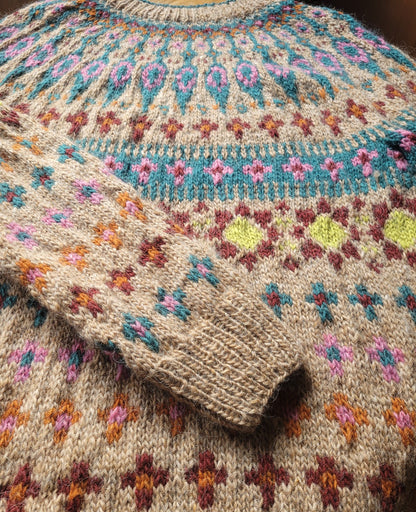 Detailaufnahme des mehrfarbigen Katmandu Musters aus Lettlopi Wolle, sorgfältig handgestrickt in traditioneller Fair-Isle-Technik. Armbündchen