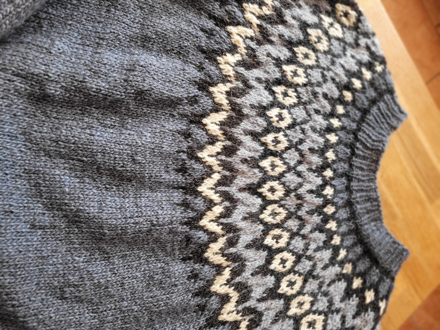 Detailaufnahme des isländischen Riddari-Musters in jeansblau, handgestrickt aus Islandwolle